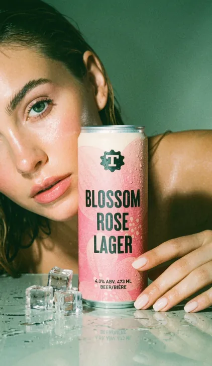 Model with a Blossom Rose Lager beer can and ice, beverage branding by Renuvo Design Inc.