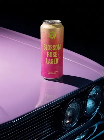 Blossom Rose Lager can staged on a classic car, beverage branding by Renuvo Design Inc.