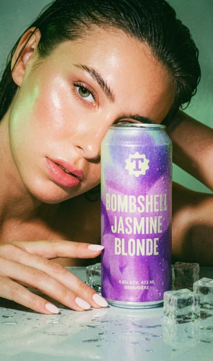 Model holding a Bombshell Jasmine Blonde lager can, craft beer branding by Renuvo Design Inc.