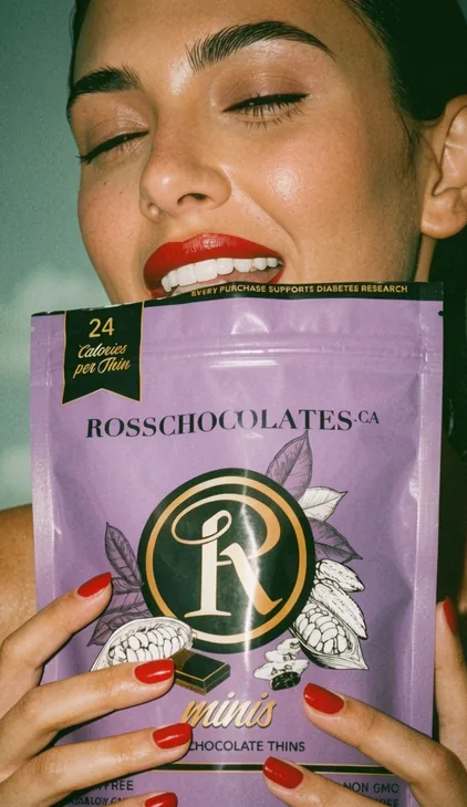 Model holding a Ross Chocolates Chocolate Thins pack, product photography by Renuvo Design Inc.