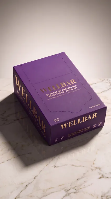 WELLBAR retail box in plum and gold on marble, packaging design by Renuvo Design Inc.